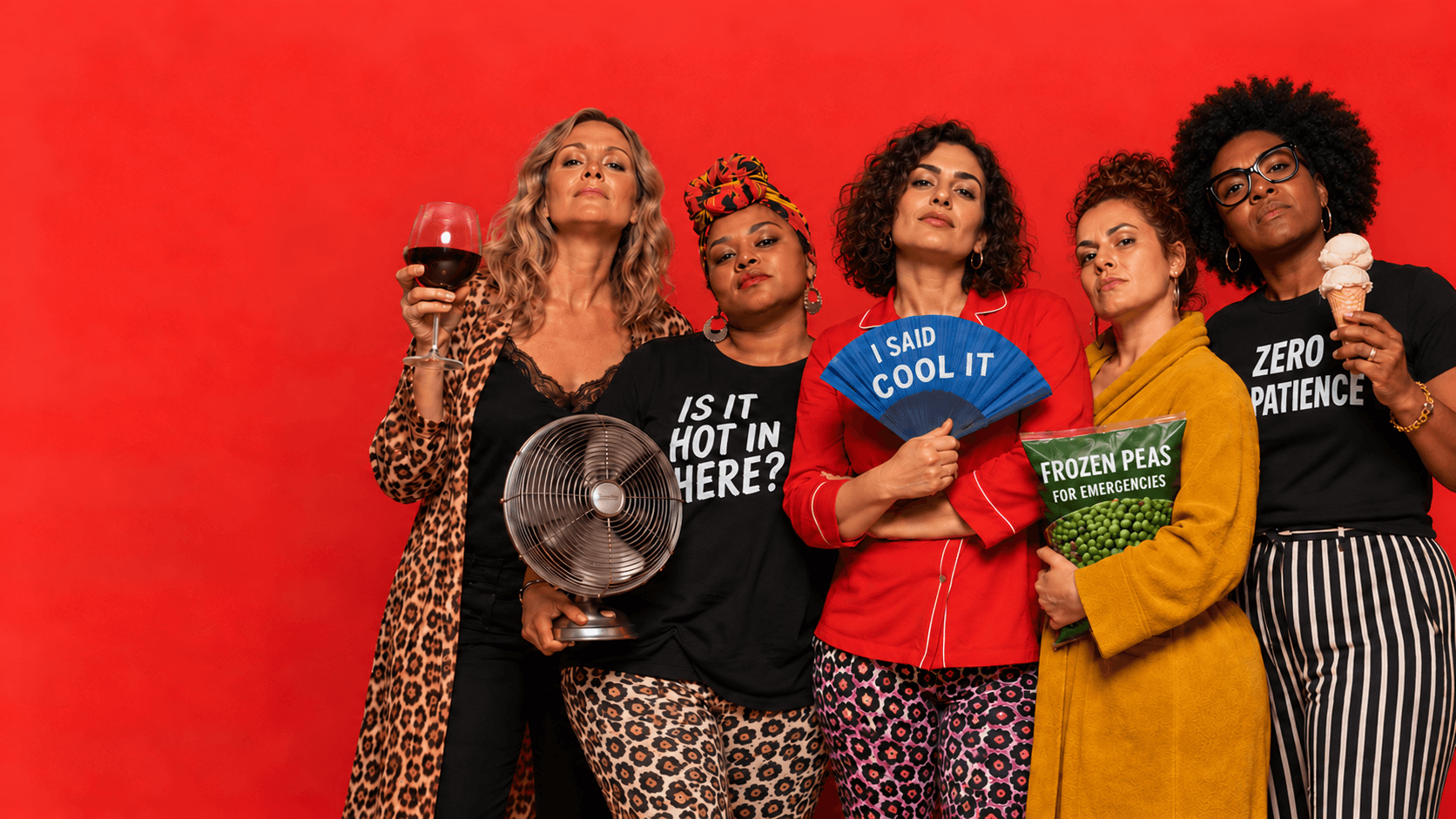 Five women together against a vivid red backdrop, holding a fan, wine glass, peas and ice cream